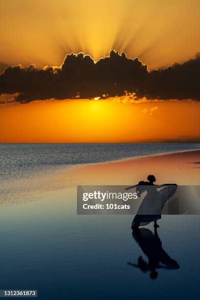 ballerina in angel outfit is dancing on water - beach fashion show stock pictures, royalty-free photos & images