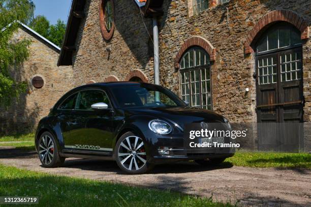 volkswagen beetle on a street - new beetle stock pictures, royalty-free photos & images