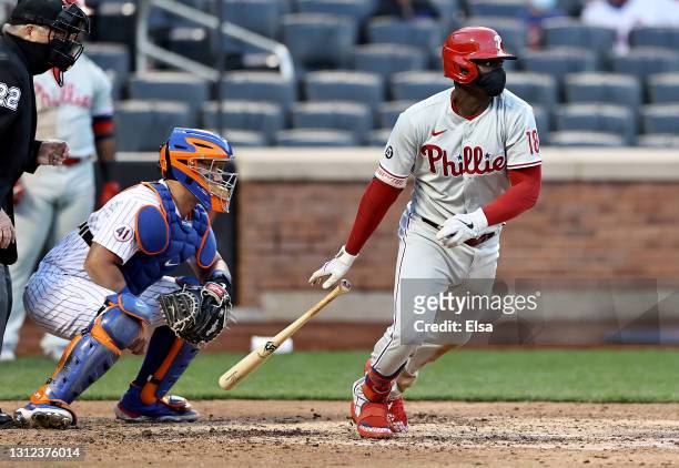 Didi Gregorius of the Philadelphia Phillies drives in a run as James McCann of the New York Mets defends in the eighth inning during game one of a...