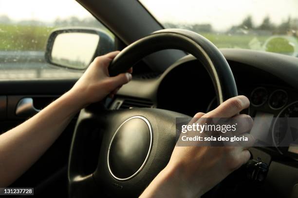woman's hand driving car - lenkrad stock-fotos und bilder
