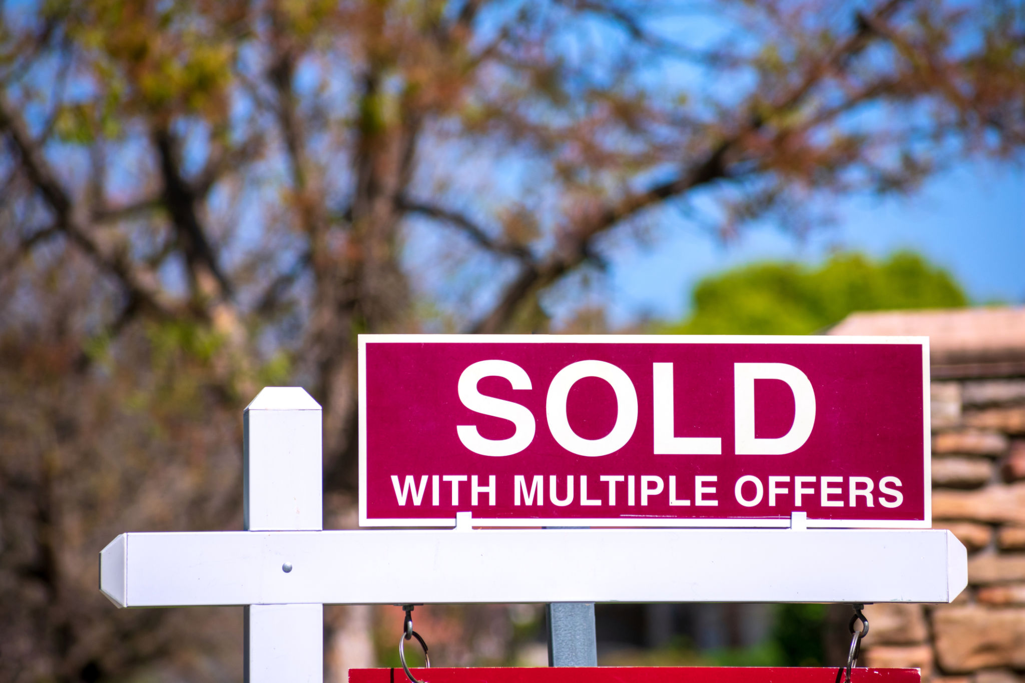 SOLD With Multiple Offers real estate sign near purchased house. SOLD With Multiple Offers real estate sign near purchased house.