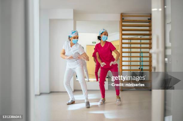 female nurses dancing and having fun at work - clinic stock pictures, royalty-free photos & images