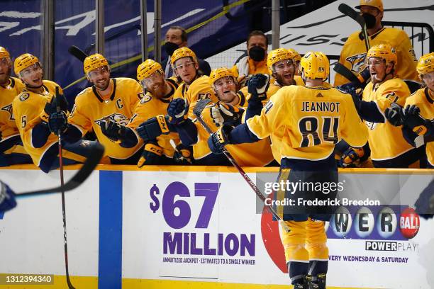 Tanner Jeannot of the Nashville Predators is congratulated by his teammates after scoring his first career NHL goal against the Tampa Bay Lightning...