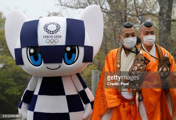 Tokyo 2020 Olympic Games mascot Miraitowa and Buddhist monks wearing protective face masks, amid the coronavirus disease pandemic, attend a ceremony...