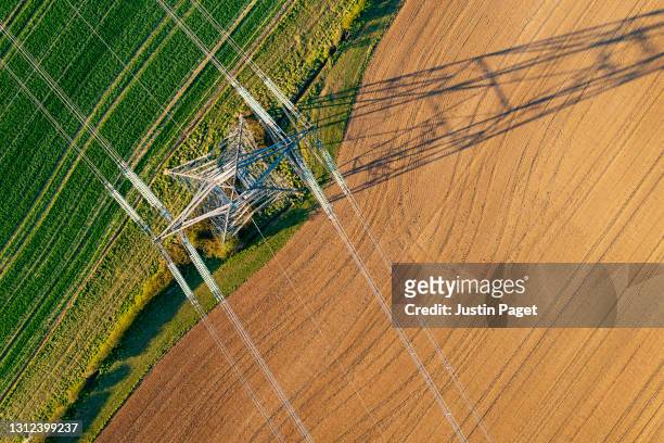 drone view of electricity pylon - alto voltaje fotografías e imágenes de stock