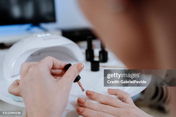 woman painting her nails at home during pandemic - home manicure stock pictures, royalty-free photos & images