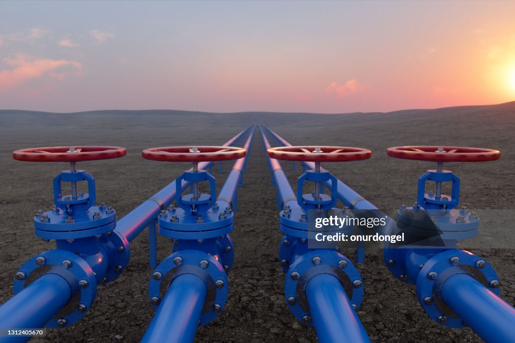 Öl- oder Gastransport mit blauen Gas- oder Rohrleitungsventilen auf Boden und Sonnenaufgang Hintergrund