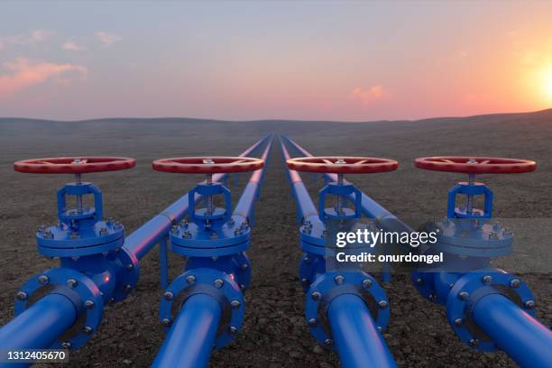 trasporto di petrolio o gas con valvole a gas blu o tubazioni sullo sfondo del suolo e dell'alba - tubatura foto e immagini stock