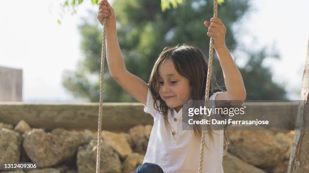 caucasian boy with long hair playing with a swing - boy with long hair stock pictures, royalty-free photos & images