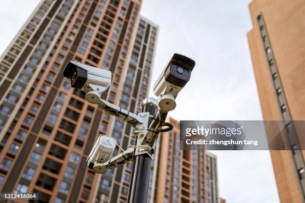 security camera against residential buildings background - malware fotografías e imágenes de stock