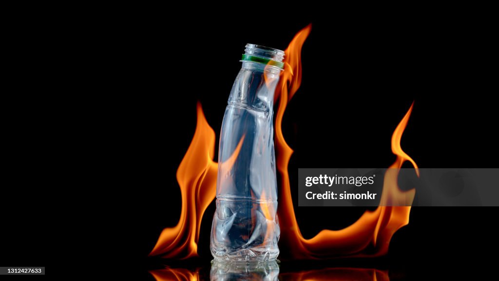 Close-up of plastic bottle melting by fire