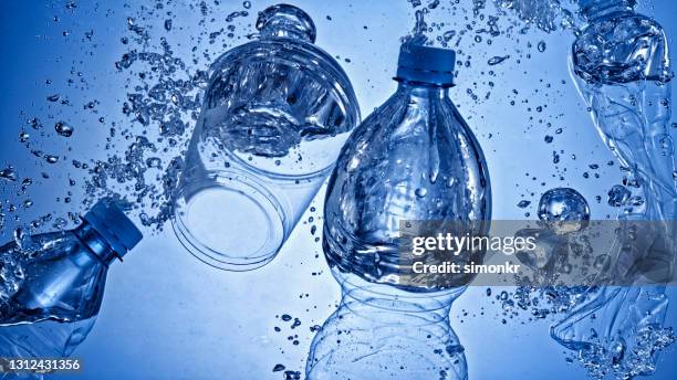 plastic bottles and plastic cups sinking in water - biodegradable stock pictures, royalty-free photos & images