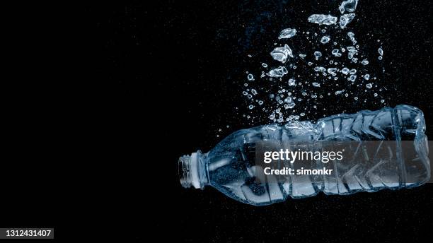 plastic bottle without cap sinking in water - water bottle splash stock pictures, royalty-free photos & images