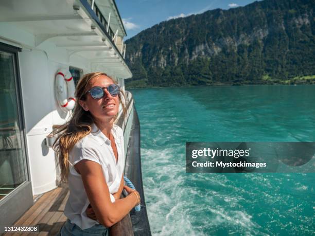 junge frau genießt bootsfahrt auf schweizer see - boat river stock-fotos und bilder