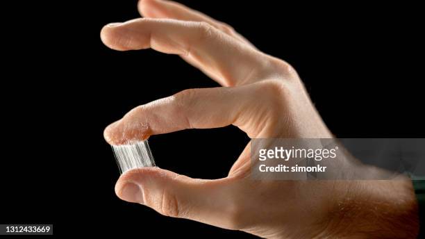 close-up of man freeing two fingers stuck together by glue - stick up stock pictures, royalty-free photos & images