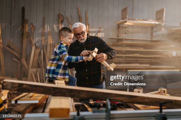 abuelo hizo un avión de madera para su nieto - abuelos fotografías e imágenes de stock