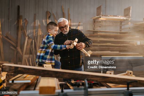 il nonno ha realizzato un aereo di legno per suo nipote - grandfather foto e immagini stock