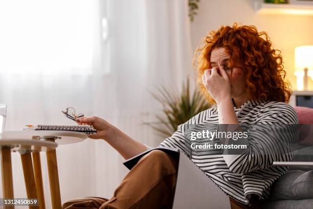 joven estudiante universitaria cansada tomando un descanso de estudiar y frotar los ojos - frotarse los ojos fotografías e imágenes de stock