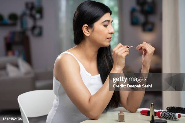 young women applying nail polish on nails;- stock photo - painting fingernails stock pictures, royalty-free photos & images