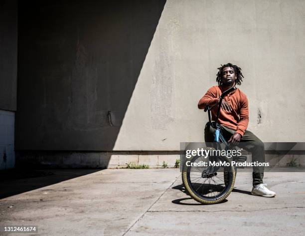 portrait of a bmx rider in warehouse environment - attitude stock pictures, royalty-free photos & images