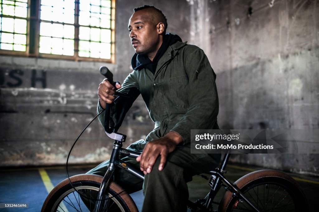 Portrait of BMX rider in warehouse environment