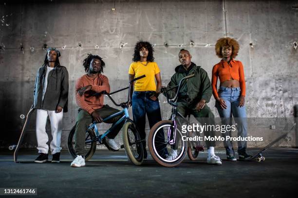 portrait of bmx riders and skateboarders in warehouse environment - moda da rua imagens e fotografias de stock