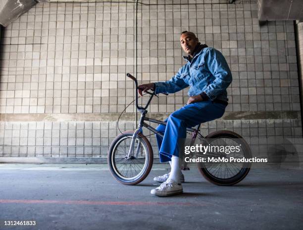 portrait of a bmx rider in warehouse environment - blauwe schoen stockfoto's en -beelden