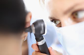 Doctor examines tympanic membrane with otoscope closeup