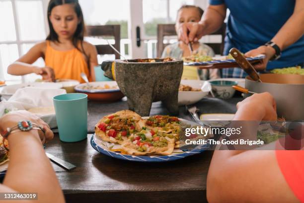 family enjoying meal together at home - mexican food on table stock pictures, royalty-free photos & images