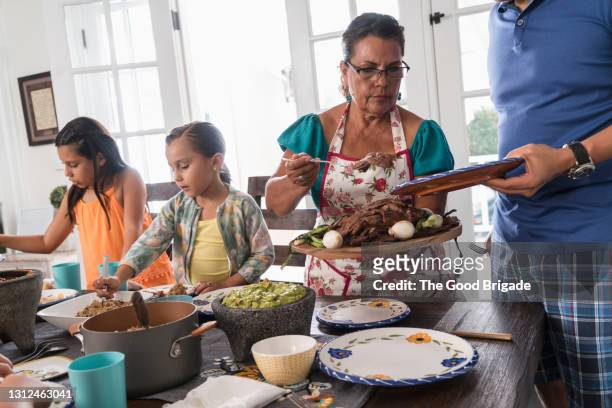 three generation family eating dinner together - mexican food imagens e fotografias de stock
