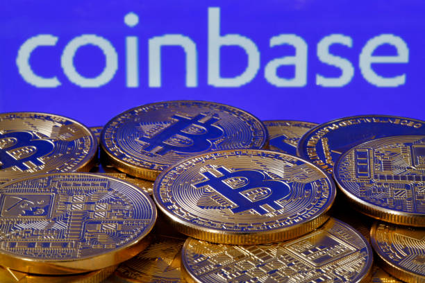 In this photo illustration, a visual representation of the digital cryptocurrency Bitcoin is displayed in front of the Coinbase cryptocurrency...