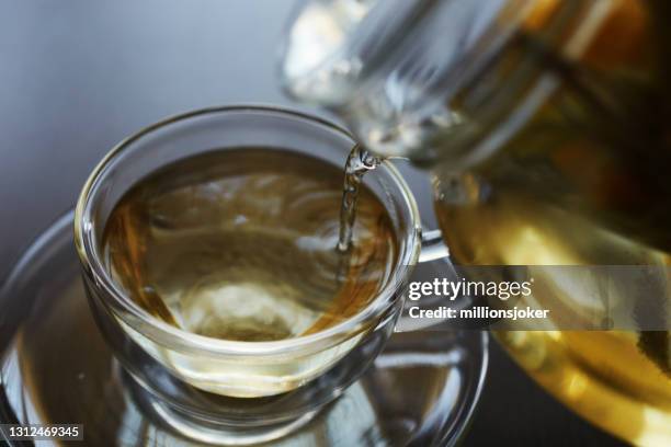 boisson chaude saine et relaxante avec un mélange de tilleul, sauge, tranche de citron, thé vert, thym - thé vert photos et images de collection