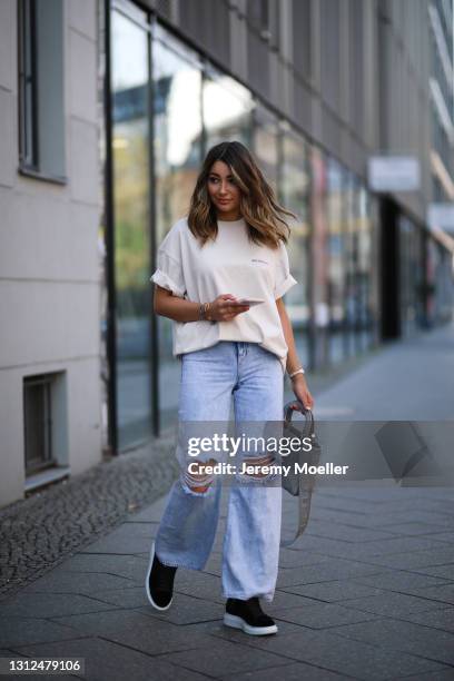 Catharina Maranca wearing beige Balenciaga shirt, Zara destroyed blue jeans, black Alexander McQueen sneakers and grey Lady Dior bag on April 11,...