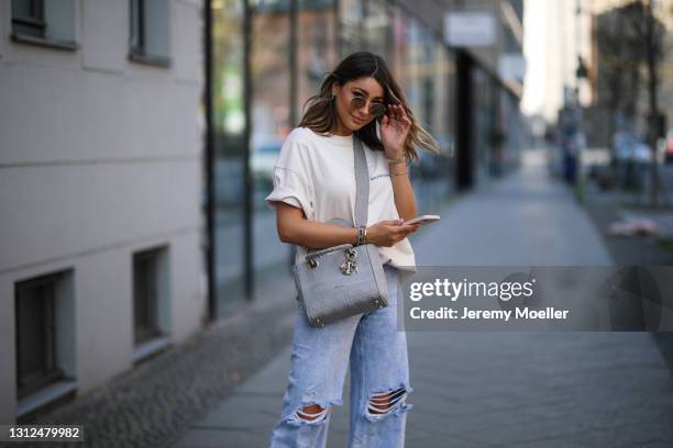 Catharina Maranca wearing beige Balenciaga shirt, Zara destroyed blue jeans and grey Lady Dior bag on April 11, 2021 in Berlin, Germany.