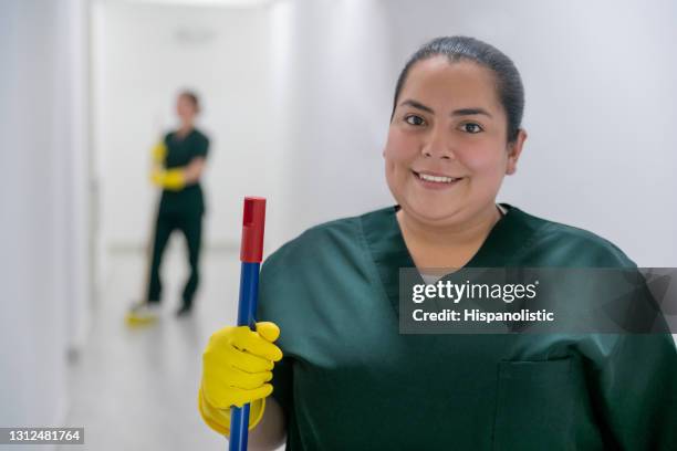 happy cleaner working at an office building sweeping the floors - woman sweeping stock pictures, royalty-free photos & images