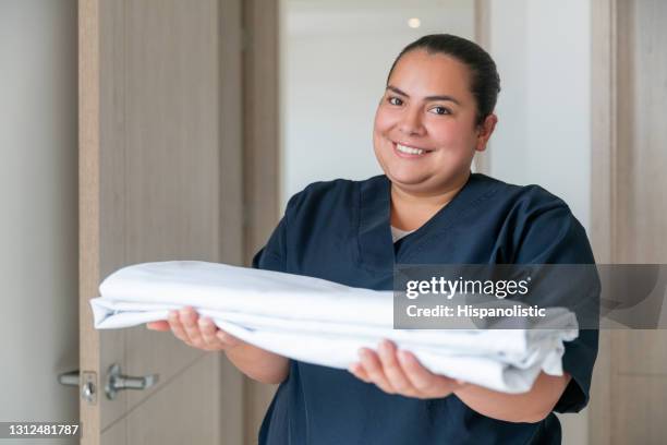 happy cleaner working at a hotel and changing the towels in a room - room service stock pictures, royalty-free photos & images