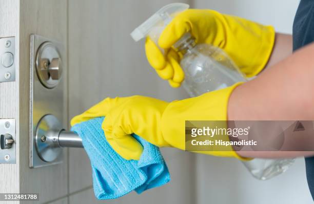 close-up on a cleaner disinfecting the door handle of the house - biosecurity stock pictures, royalty-free photos & images