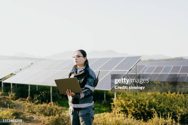 asian female engineer working at solar power station - fornitura di energia foto e immagini stock