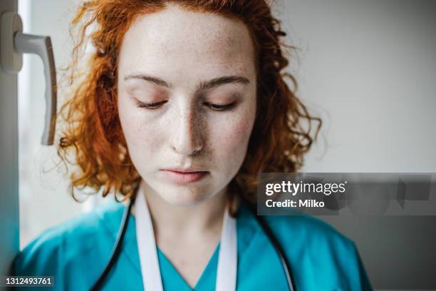 a portrait of a sad female doctor - sad nurse stock pictures, royalty-free photos & images