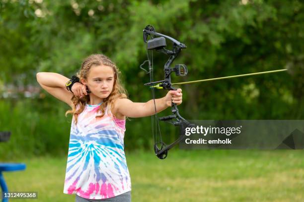 close-up of archery girl who just released arrow - curly arrow stock pictures, royalty-free photos & images