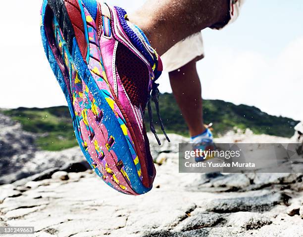 man running on rocks, rearview - sole of foot stock-fotos und bilder