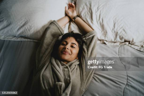 ung kvinna vilar liggande i sängen - morgonrock bildbanksfoton och bilder