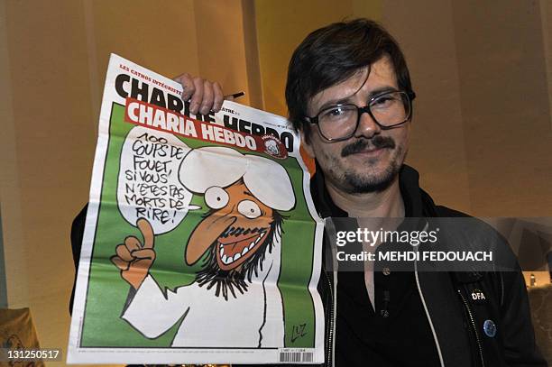 The Charlie Hebdo' s cartoonist Luz shows a special edition of French satirical magazine Charlie Hebdo, on November 3, 2011 during an editorial...