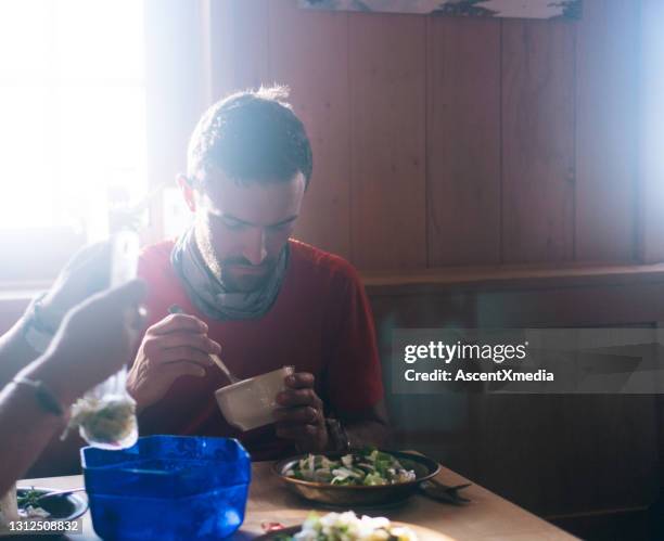 cross-country runner eats soup and salad inside of hut - athlete stock pictures, royalty-free photos & images