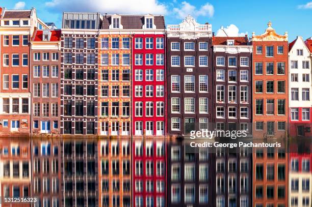 row of amsterdam houses and reflection in the canal - amsterdam stock-fotos und bilder