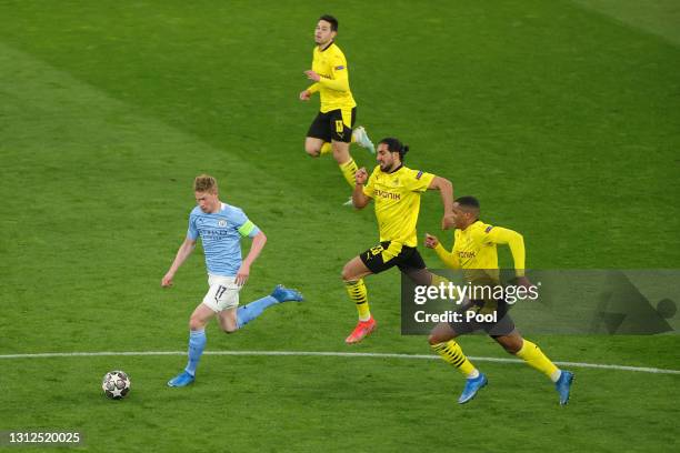 Kevin De Bruyne of Manchester City runs with the ball as he is chased by Emre Can and Manuel Akanji of Borussia Dortmund during the UEFA Champions...