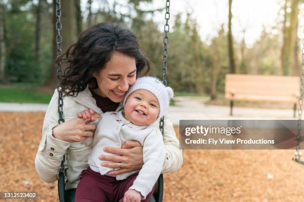 mama und baby lachen zusammen im park - eurasische herkunft stock-fotos und bilder