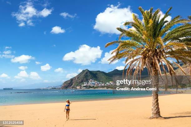 tourist walking in playa las teresitas, santa cruz de tenerife, tenerife, canary islands - santa cruz de tenerife beach stock pictures, royalty-free photos & images