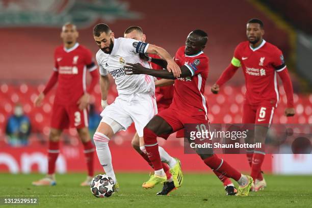 Karim Benzema of Real Madrid is challenged by Sadio Mane of Liverpool during the UEFA Champions League Quarter Final Second Leg match between...