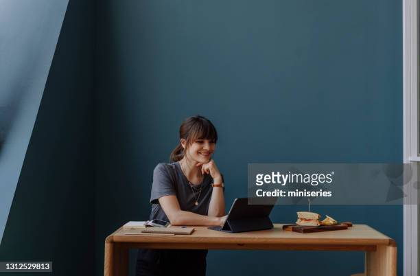 belle femme d’affaires heureuse surfant sur le net sur sa tablette numérique pendant la pause déjeuner (copy space) - image dépouillée photos et images de collection